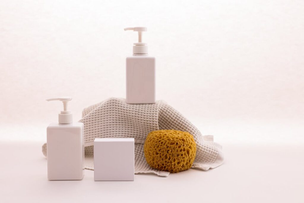 Crafting Captivating Headlines: Your awesome post title goes here White pump bottles with a natural sponge on a textured cloth, ideal for beauty product mockups.